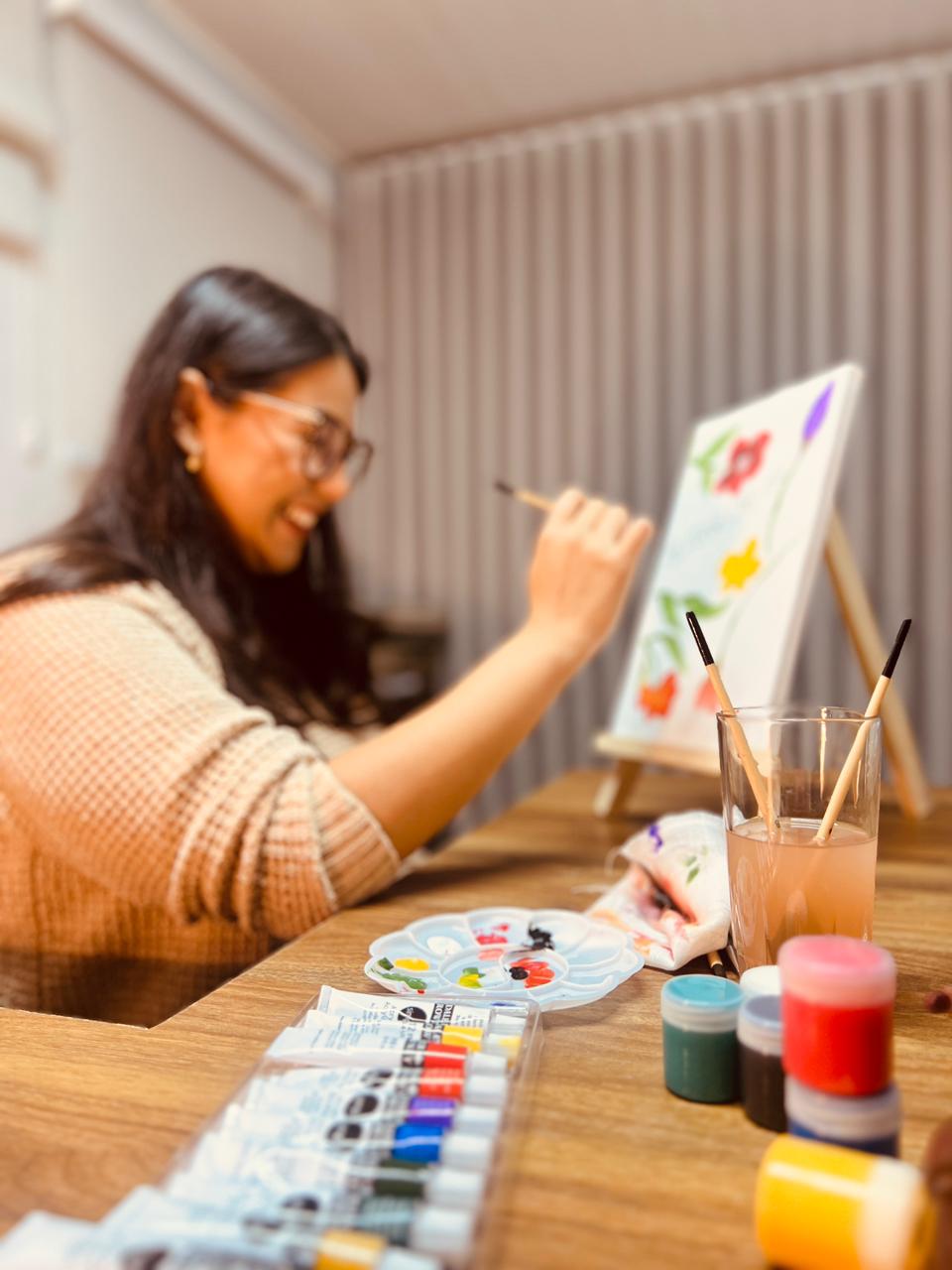 Participante pintando uma tela durante uma oficina de pintura